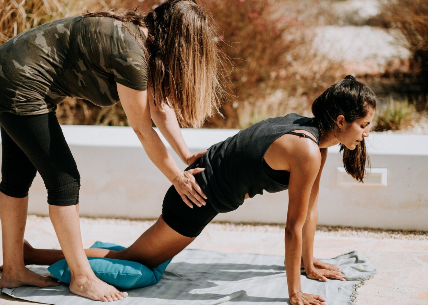 woman in black tank top and black shorts kneeling on mat
