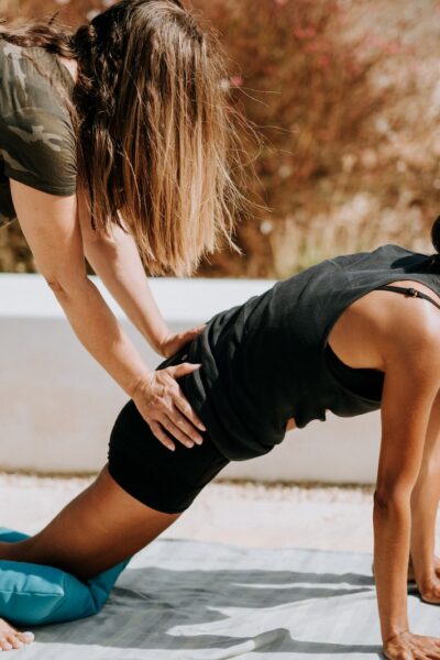 woman in black tank top and black shorts kneeling on mat